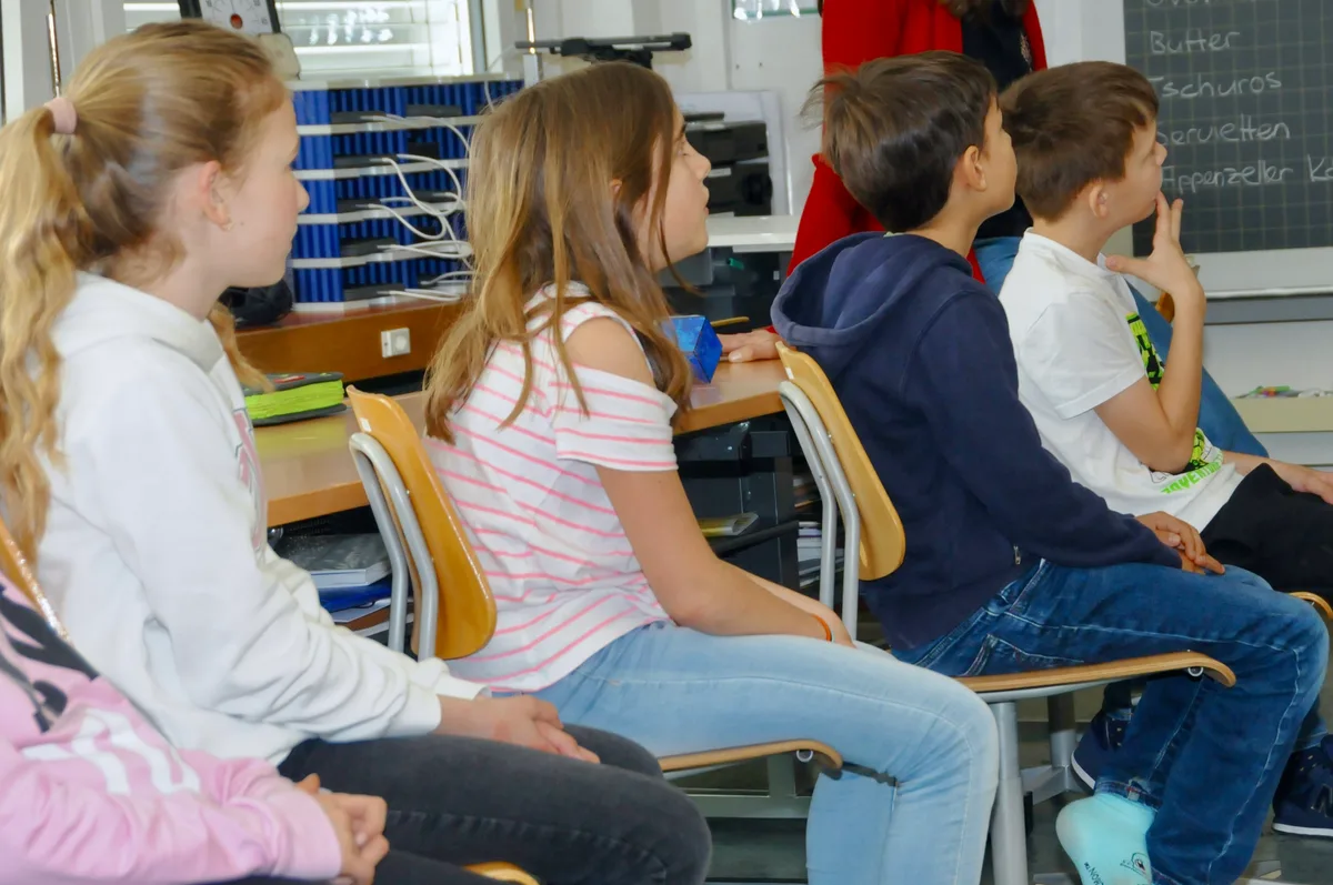 Man sieht Schulkinder ihr Schulprojekt vorstellen.